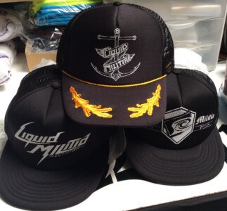 These Liquid Militia logos were screen printed onto transfer paper then cut apart and heat pressed onto the hats. Heat transfer, heat pressed trucker hats